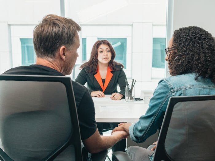 Woman in Black and Orange Blazer Sitting by the Table