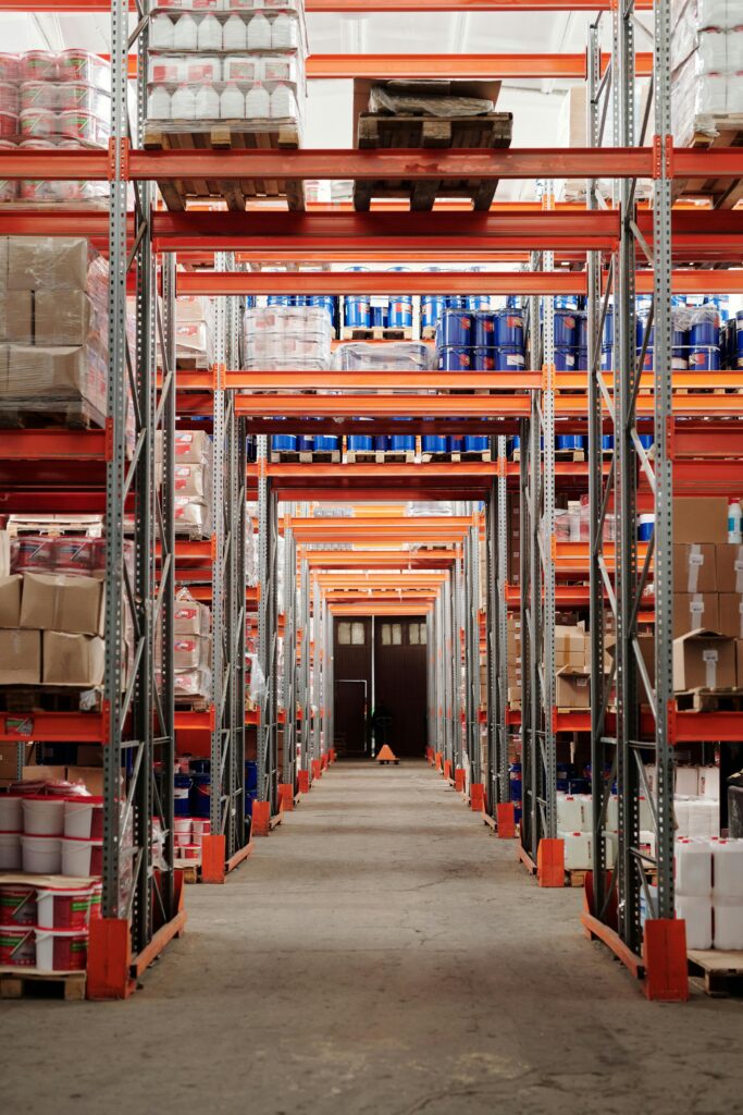 pexels-photo-4483608-4483608 A modern warehouse interior showcasing organized shelves and pallets for efficient storage.